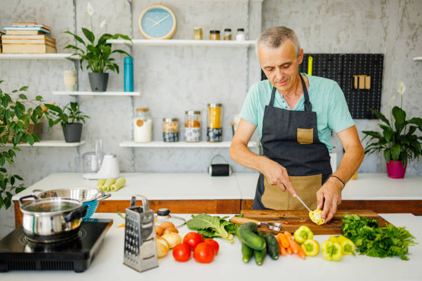 istock Smiling man cooking at home 1412679666