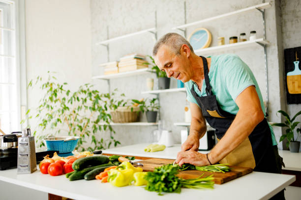 istock Happy man cutting vegetables in the kitchen 1412679711