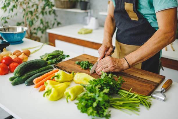 istock Man's hands cutting vegetables in the kitchen 1412680462