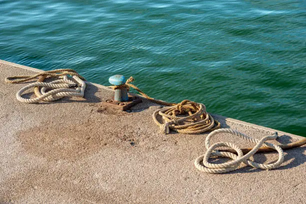 Photo of Rusty Mooring Bollard with Ropes in the Port - La Spezia Italy