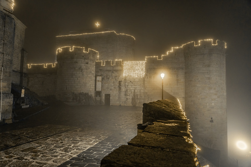 Puebla De Sanabria, Spain - December 30, 2021: Castle of Condes de Benavente with christmas illumination at night in the the medieval village of Puebla de Sanabria, Zamora, Castilla y Leon, Spain.