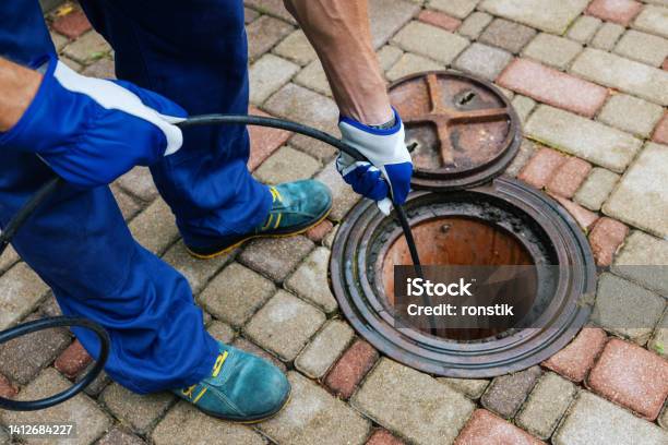Sewer Cleaning Service Worker Clean A Clogged Drainage With Hydro Jetting Stock Photo - Download Image Now