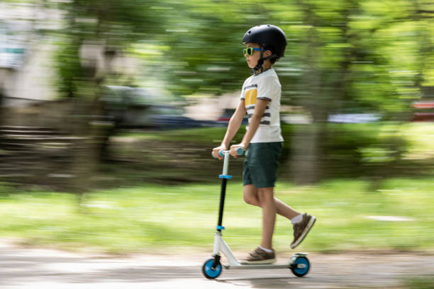 istock Kid riding push scooter in the park 1412684721