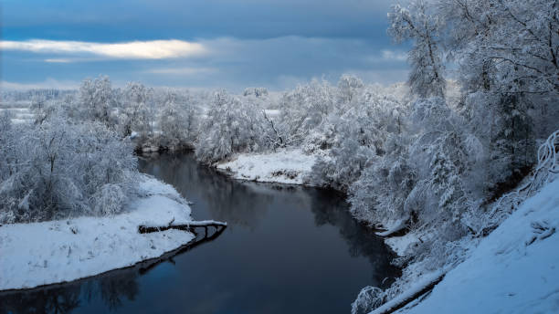 istock Winter landscape. Unfrozen river in forest. Snow on shore and trees. 1412685184