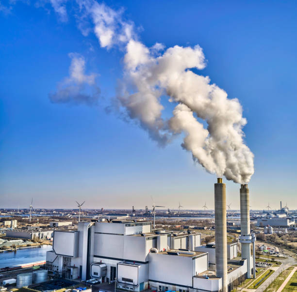 istock factory with smoke into the blue sky. 1412686314