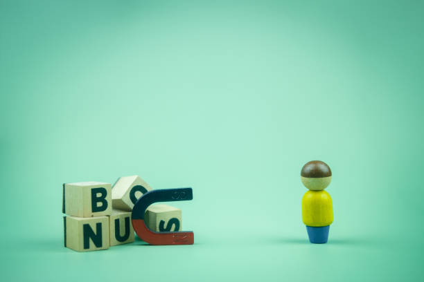 istock Letter block in word BONUS and magnet magnetize human motivation in work. 1412686853
