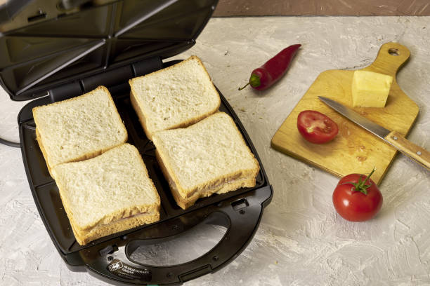 istock sandwich maker cheese sausage and bread on the table 1412695902
