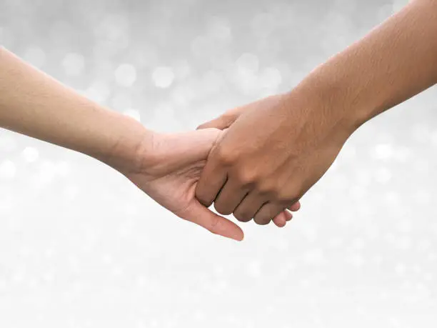 Photo of Image of a couple holding hands on shining bokeh background