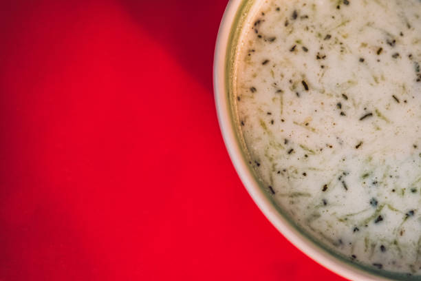 A bowl of tzatziki halves visible. Space for text. Red table floor is empty