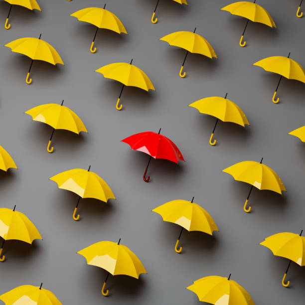 specjalny czerwony parasol we wzór żółtych parasoli na szarym tle. koncepcja przywództwa - leadership standing out from the crowd sports team individuality zdjęcia i obrazy z banku zdjęć