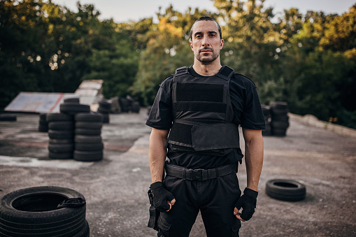 Portrait of a SWAT team soldier standing on training grounds outdoors.