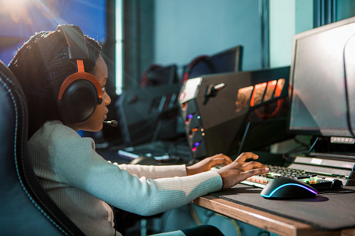 Beautiful young alternative black female child  playing online games in a Esports Gaming Cafe