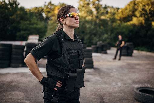 Portrait of a SWAT team female soldier standing on training grounds outdoors.
