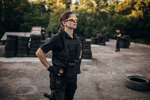 Portrait of a SWAT team female soldier standing on training grounds outdoors.