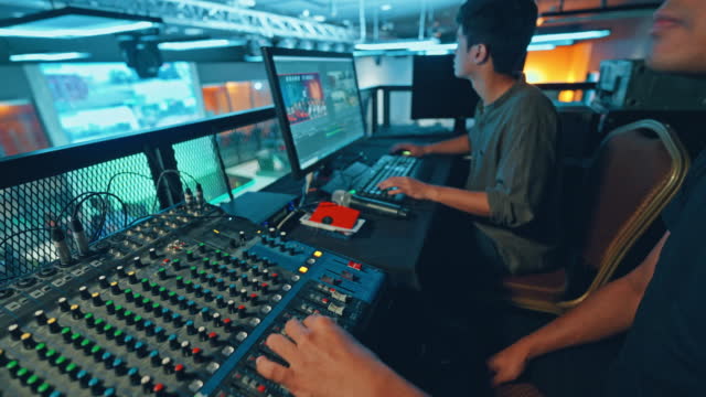 Asian sports event crew working at backstage with control panel on stage lighting , sound system and lighting effect