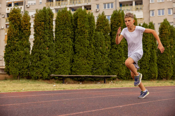istock Kid sprinting on the track. Running in full speed. 1412708530