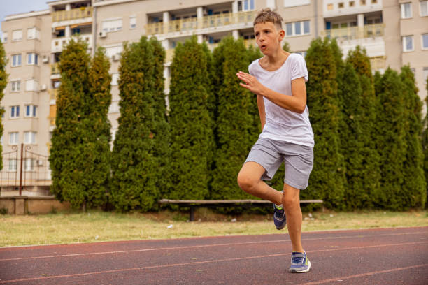 istock Kid sprinting on the track. Running in full speed. 1412708805