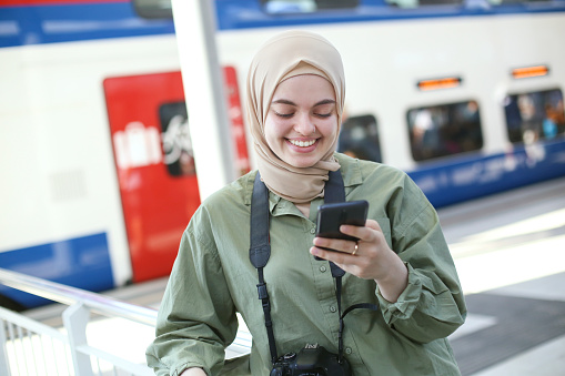 Middle-eastern female tourist traveling at a railway station. About 25 years old, Arab woman.