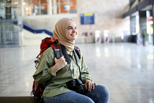 Middle-eastern female tourist traveling at a railway station. About 25 years old, Arab woman.