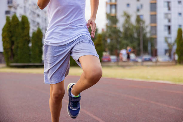 istock Kid running on the track. Only legs. 1412711182