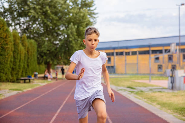 istock Kid sprinting on the track. Front view. 1412711519