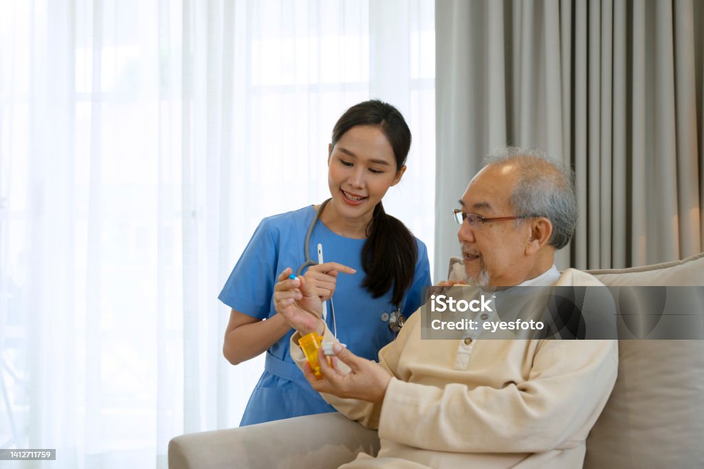 Senior man is listening information about medicine from nurse. Senior man is listening information about medicine from nurse. Home health care concept. Patient Stock Photo