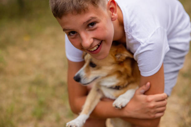 istock Young boy playing in backyard with his dog. Hugging. 1412712537