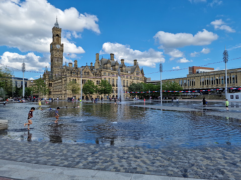 Bradford, United Kingdom - June 3, 2022: Children playing in City Park and Mirror Pool in Bradford, West Yorkshire