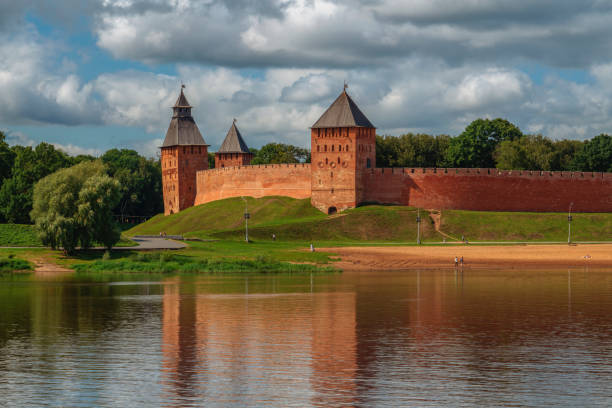 blick auf die mauer des nowgower kremls, die dvortsovaya und spasskaya towers, den stadtstrand vom volkhov river an einem früh bewölkten sommermorgen, veliky novgorod, novgorod region, russland - novgorod stock-fotos und bilder