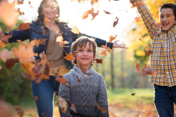 istock Admiring Fall Leaves with his Family 1412725040