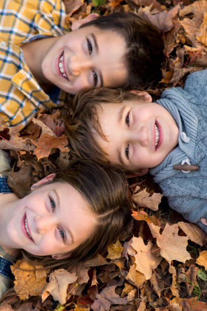 istock Children Laying in the Leaves 1412725044