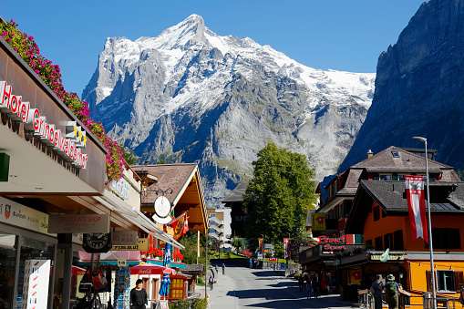 Grindelwald, Switzerland - 21 September 2017: Hotels, alpine residential houses, various shops at the foot of the rocky mountain shows a wonderful holiday destination.