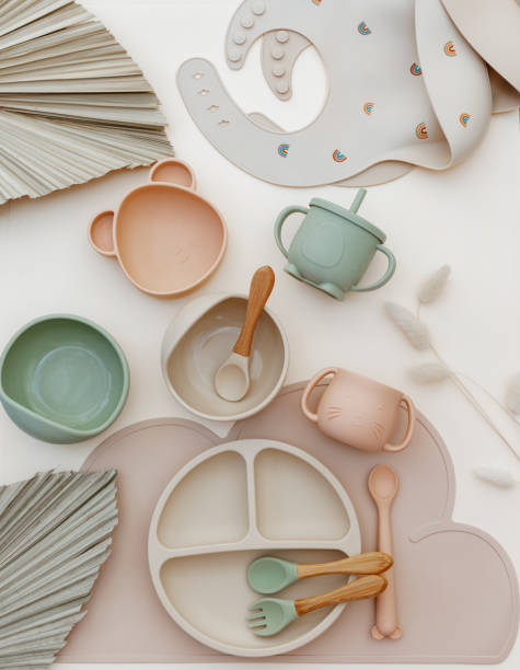 istock Top view modern silicone dishware plate and spoon. Serving baby, first feeding concept. Kids tableware and bib on light background. Instagram use. Flat lay, copy space, top view 1412729582