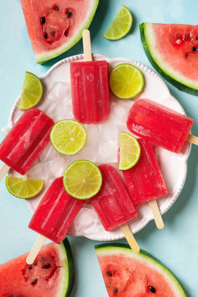 istock Ice cream popsicle watermelon with ice cube and lime on blue background 1412730015