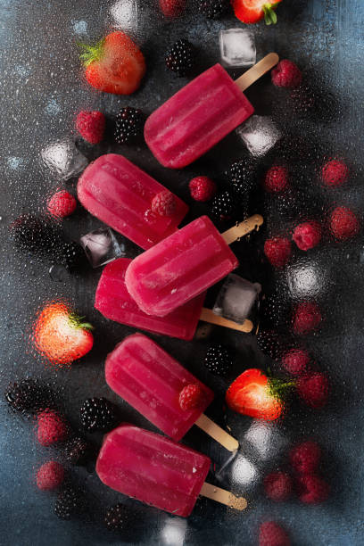 istock Ice cream popsicle berries with ice cube on dark background 1412730019