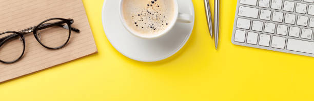 istock Office yellow backdrop with coffee, supplies and computer 1412730842