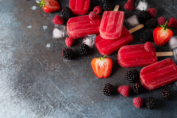istock Ice cream popsicle berries with ice cube on dark background 1412731457