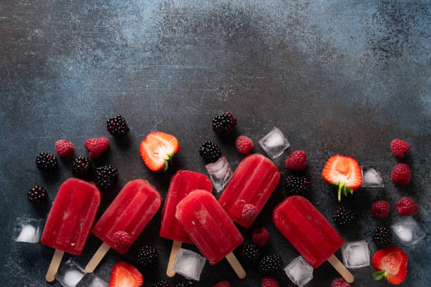 istock Ice cream popsicle berries with ice cube on dark background 1412731466