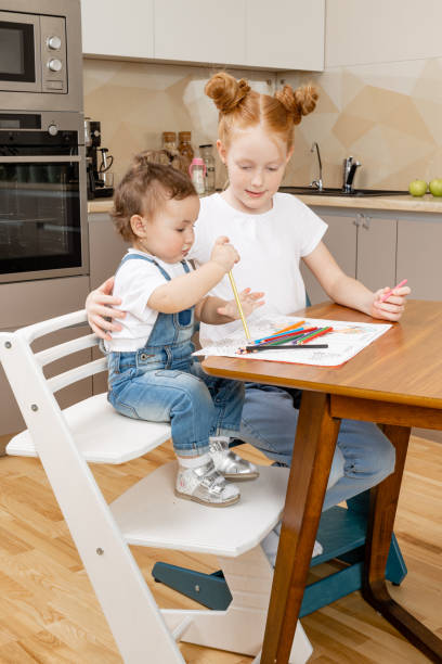 istock sister biting an apple from her younger sister 1412733297