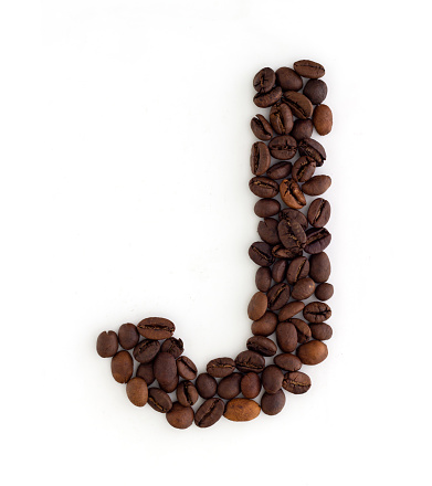 Capital letter J made from coffee beans. Coffee font. Alphabet made from coffee beans. White background. Roasted coffee beans.