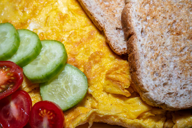 istock Scrambled eggs, cucumber, tomatoes and toast bread 1412737237
