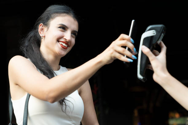 istock young woman paying with smartphone in a cafe 1412737335