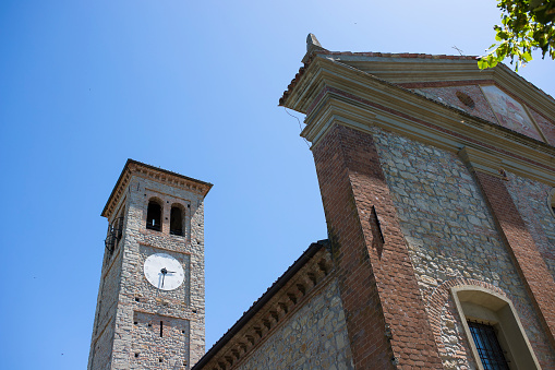 Facade and bell tower of Santa Maria and San Giorgio church in Fortunago, one of the most charming villages of Oltrepò Pavese, Lombardia countryside, Italy.