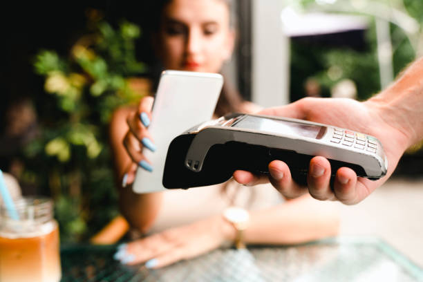 istock young woman paying with smartphone in a cafe 1412739956