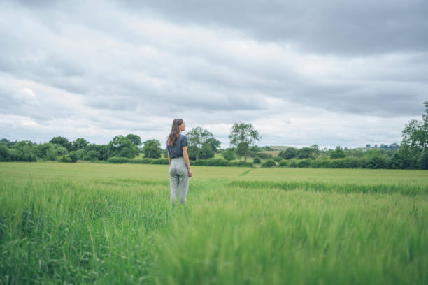 Young woman walks through green fields