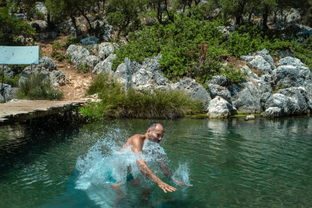 istock 35 year old man jumping from wooden bridge into cold spring water 1412741105