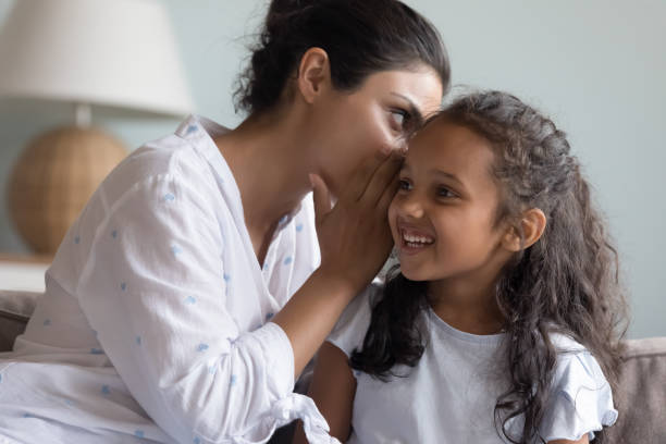 istock Young Indian mom sharing secret with happy daughter 1412746812
