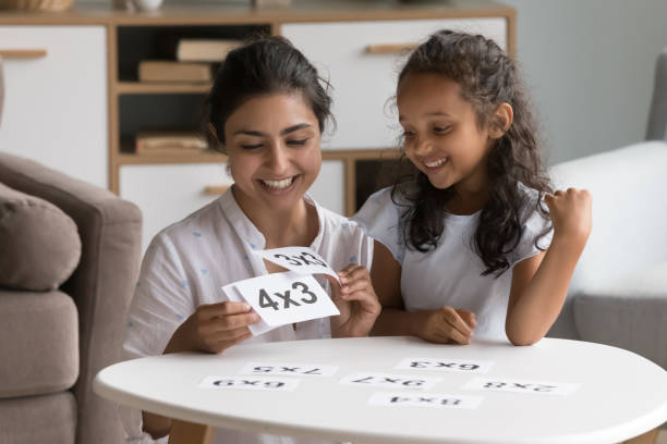 glückliche indische kindertagesstättenlehrerin, die dem kleinen kind karteikarten zeigt - family house flash stock-fotos und bilder