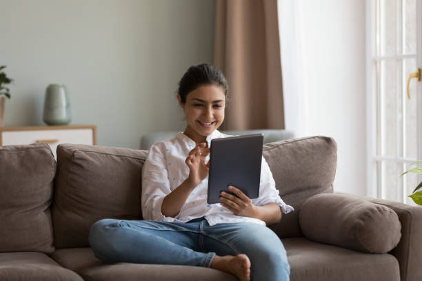 Happy millennial Indian girl using online app on digital device