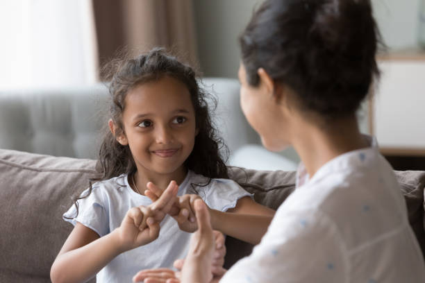 istock Happy cute Indian kid girl talking to mother, using hands 1412746876